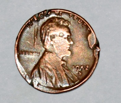 1952 wheat penny with off-center strike showing crescent-shaped blank area and partial Lincoln portrait